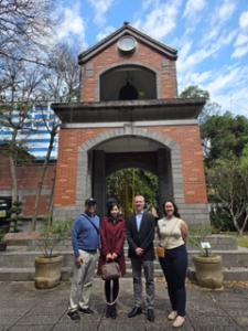 A group of people standing in front of a bell tower with Thurber House in the background Description automatically generated